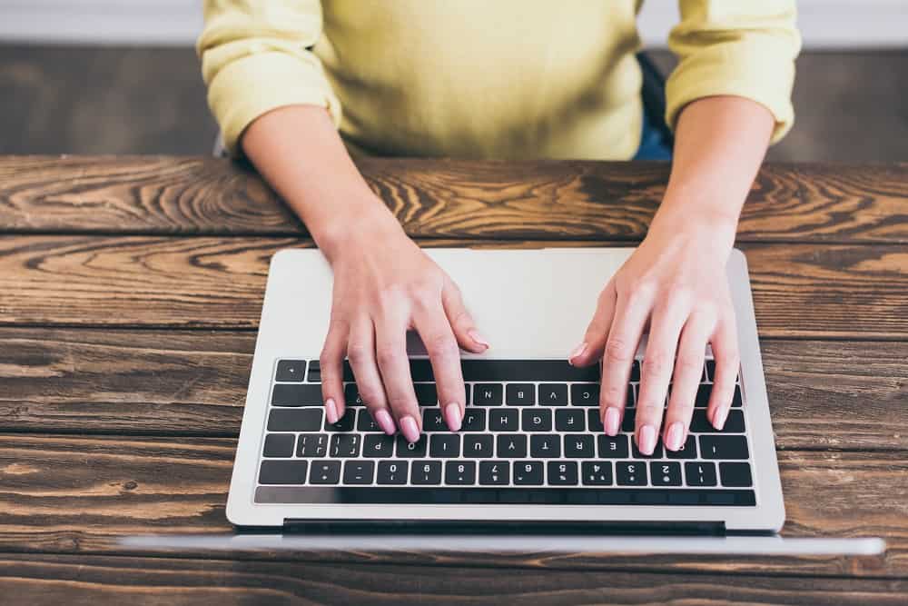 A freelance writer typing on a computer